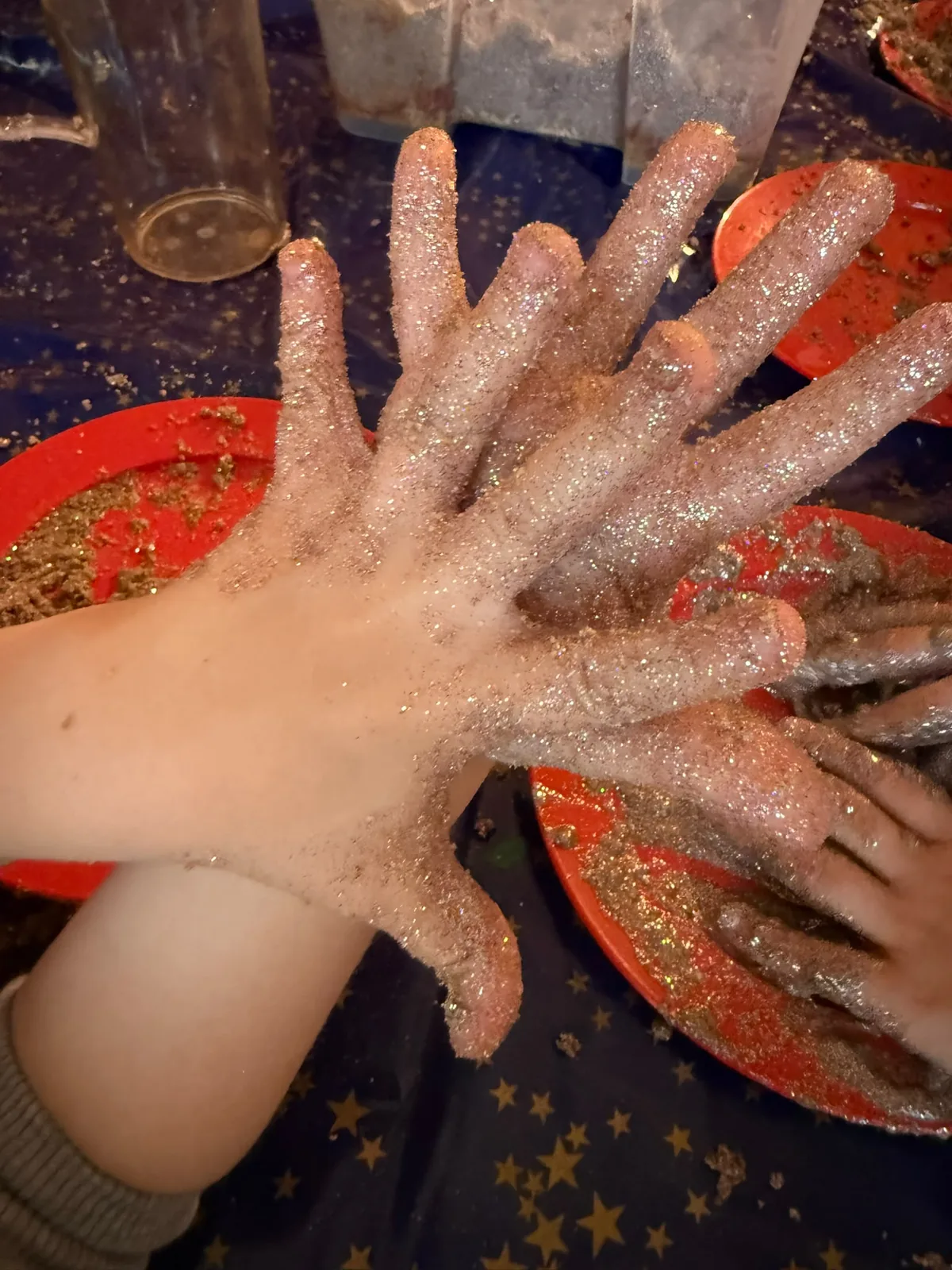 Kinderhände voller Glitzer beim Basteln im Finch Atelier